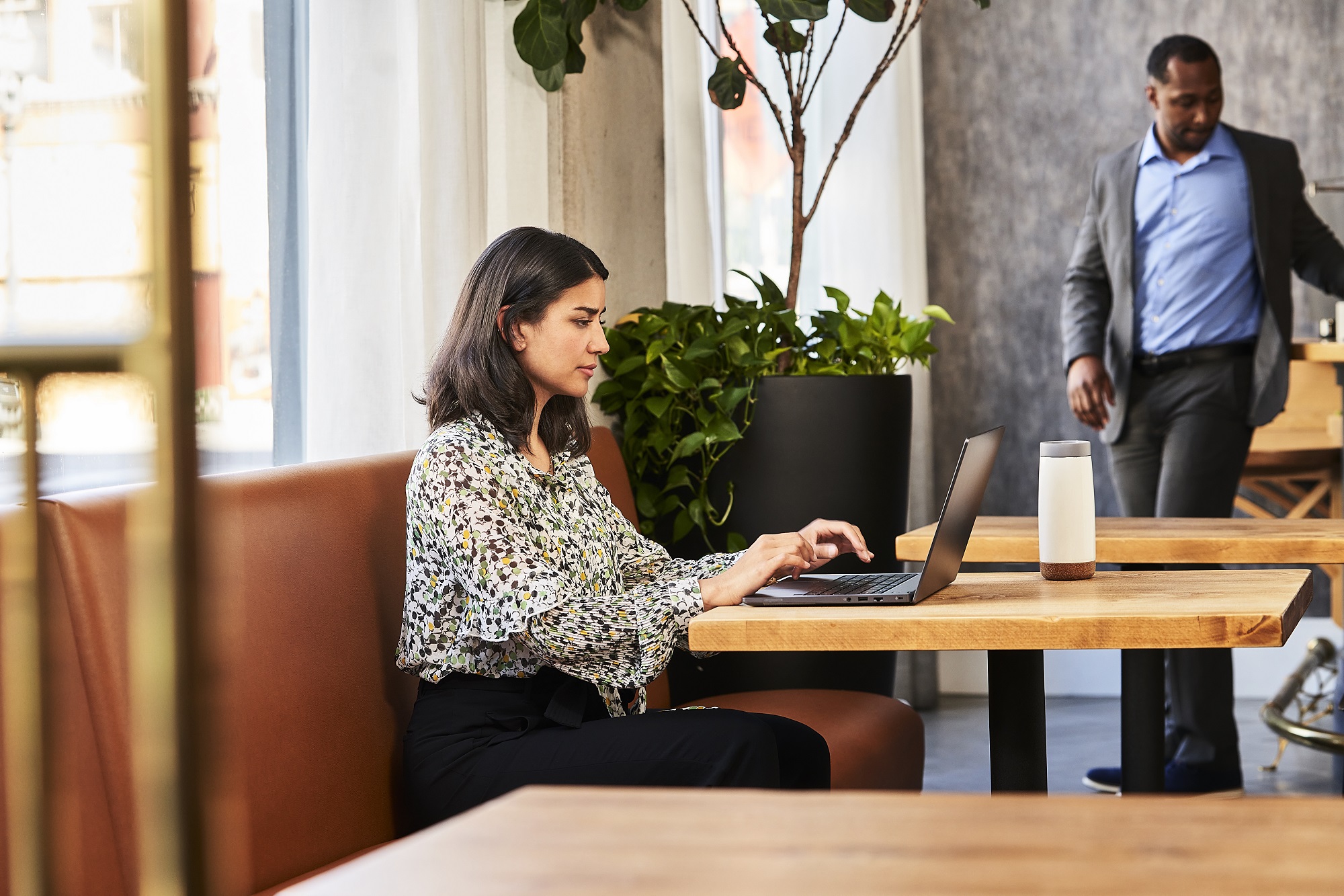 Young woman in a restaurant with Intel NUC 14E Laptop chassis el